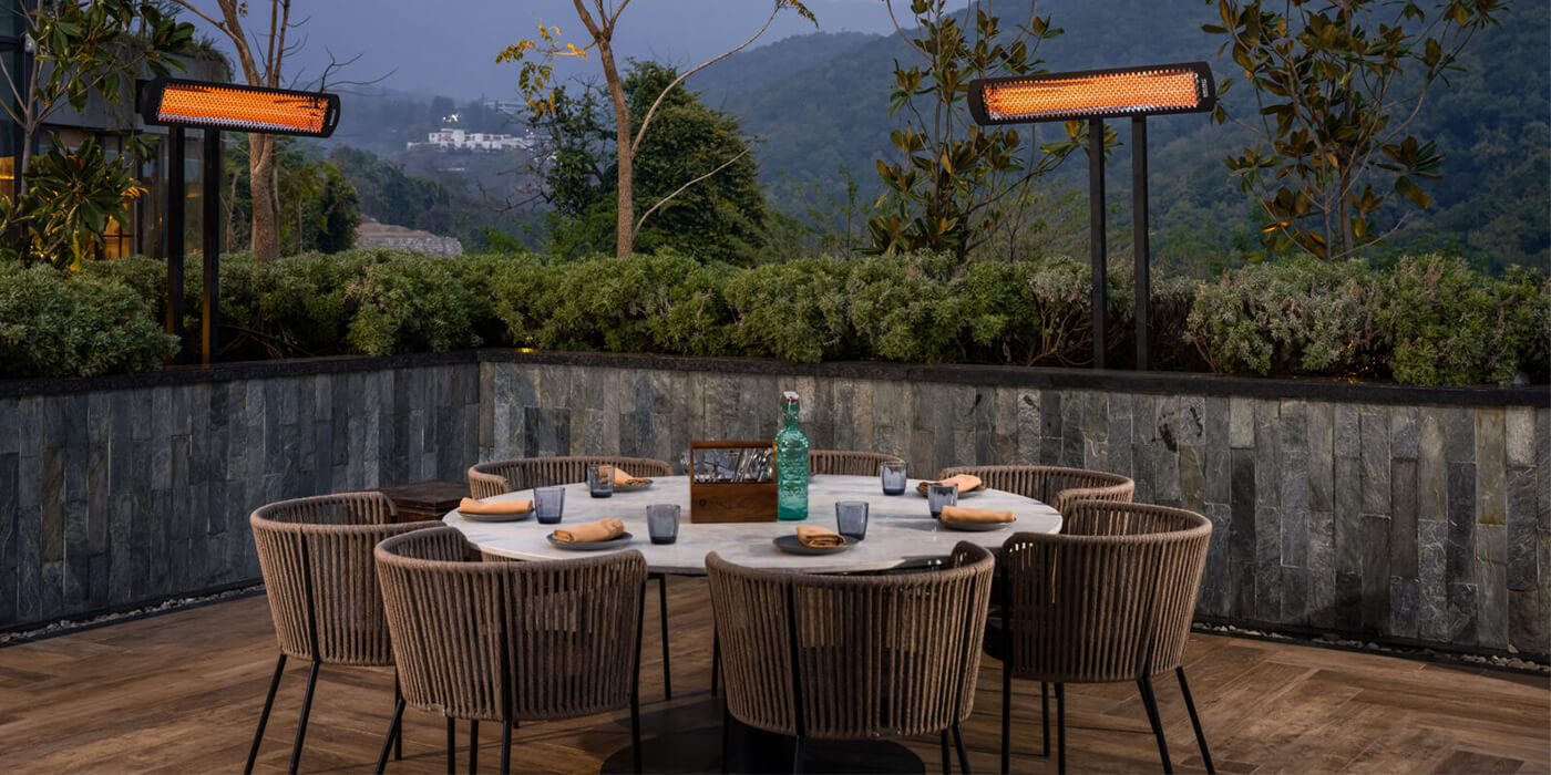 A outdoor dining space with two mounted patio heaters from Infratech