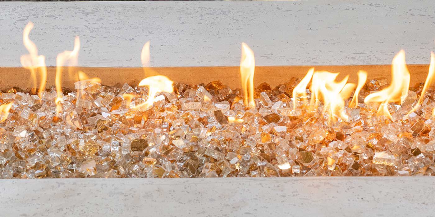 A gas fire pit with reflective, gold-colored fire glass media
