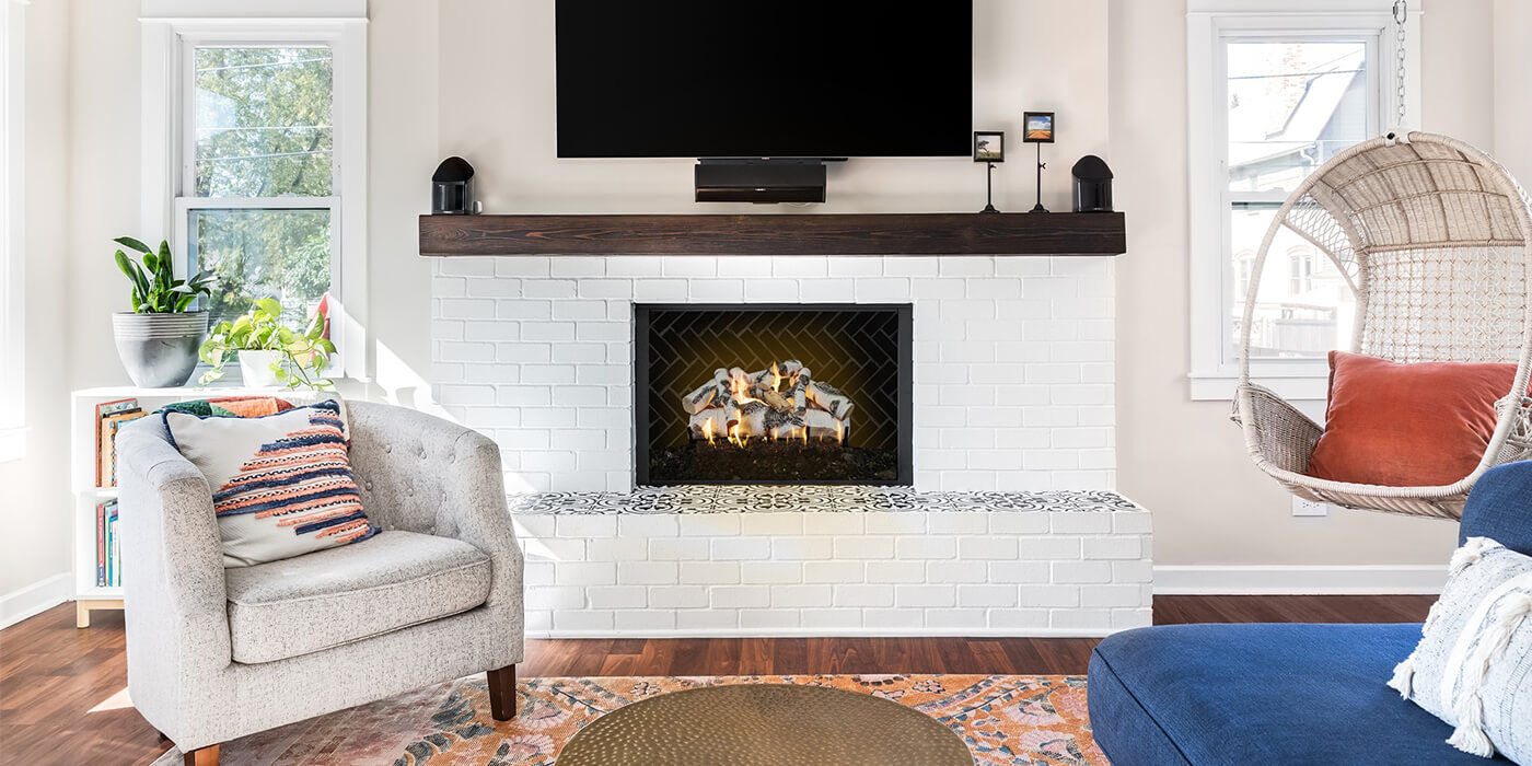 A contemporary living room with a small rectangular gas fireplace and a birch style gas log set.