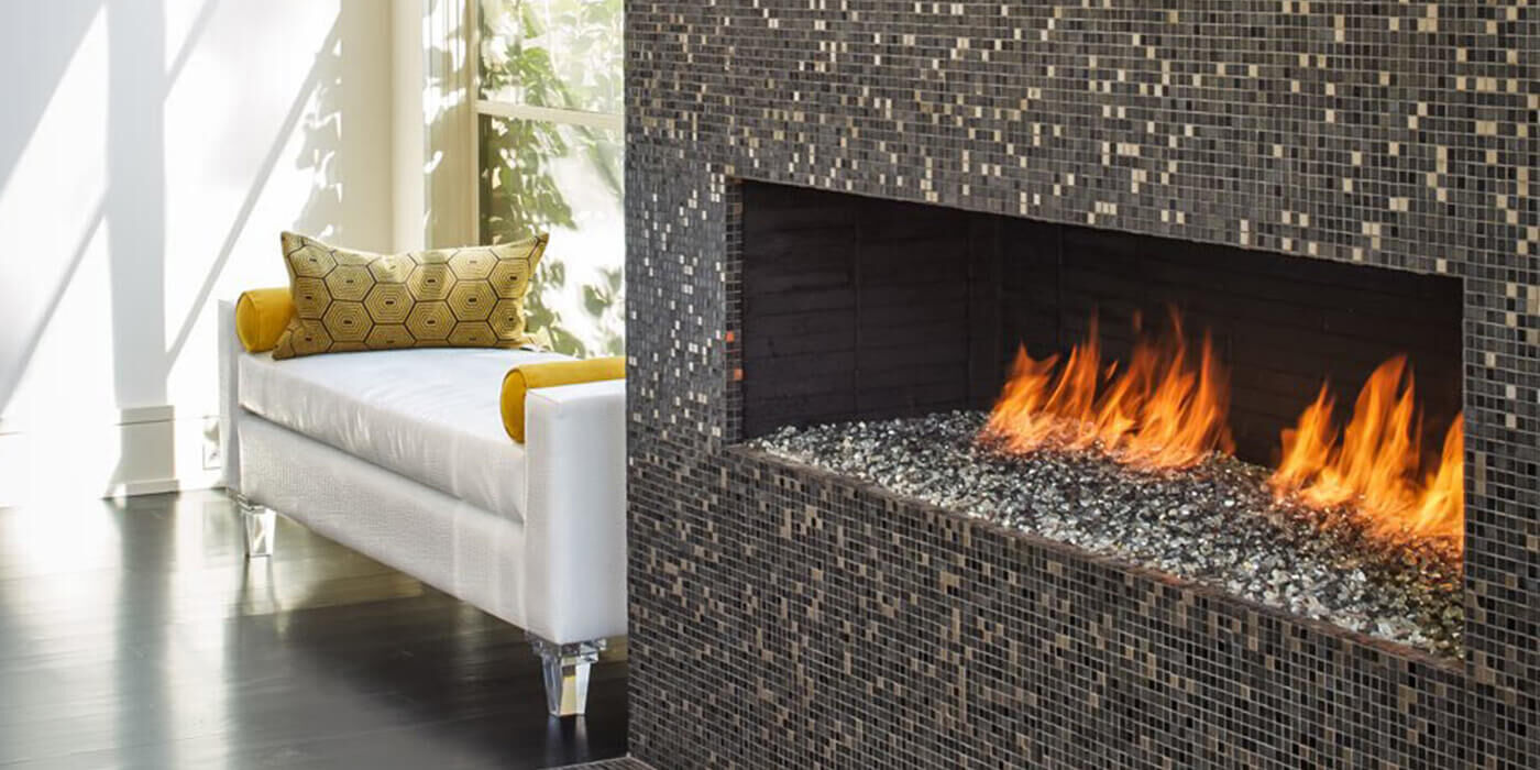 A custom Isokern gas fireplace finished with tiles and filled with fire glass media