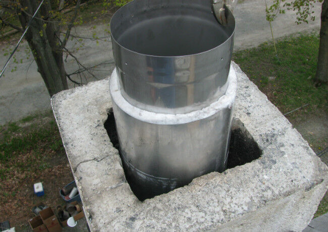 Stainless steel chimney liner sticking out of a masonry chimney
