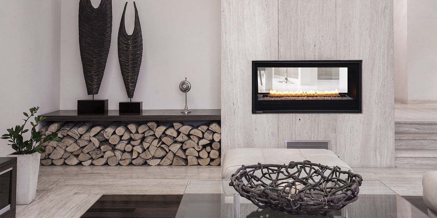 A modern-meets-rustic living room with a see-through linear gas fireplace and a decorative wood storage area with real logs