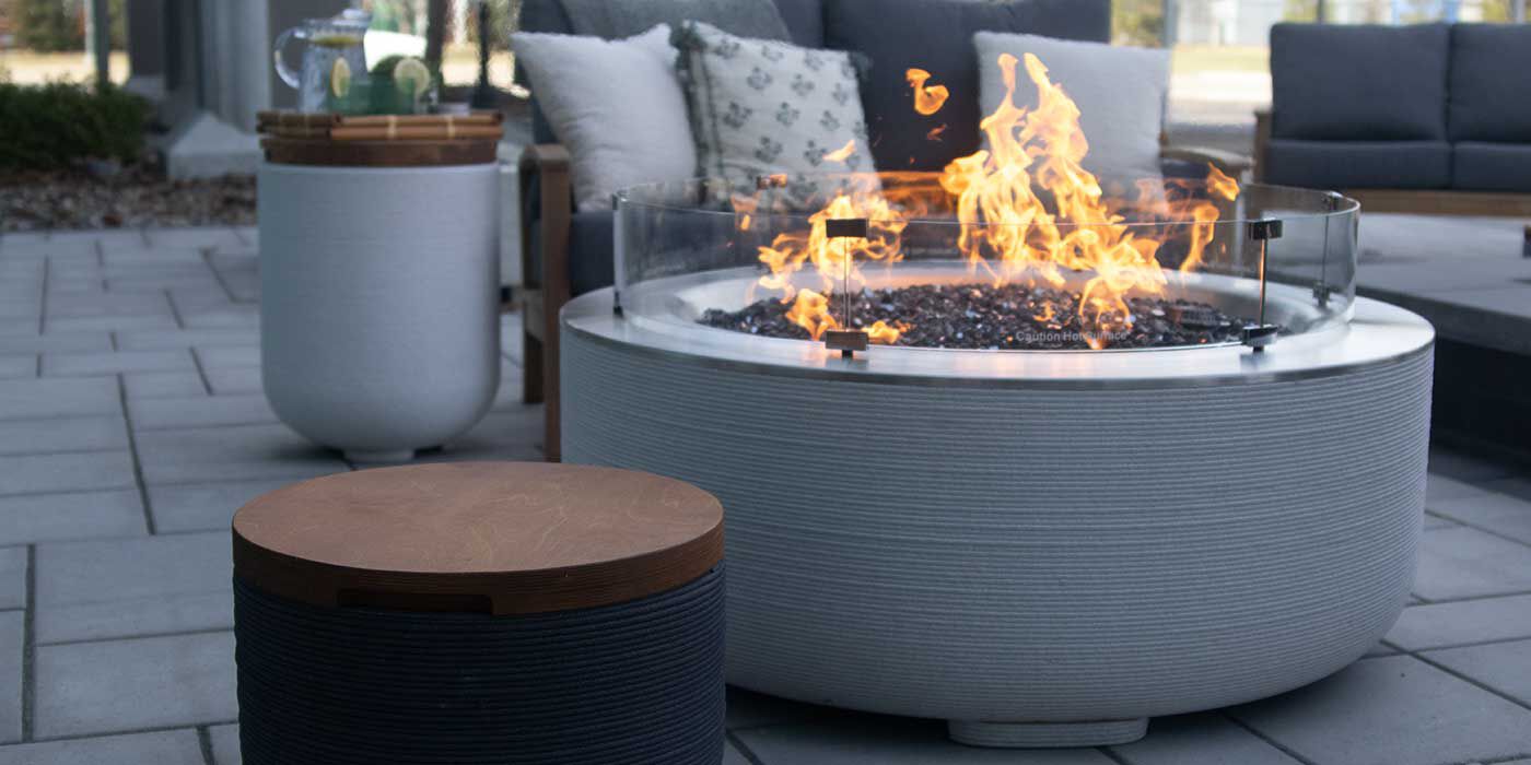 The ReForm Stack Gas Fire Pit by FlameCraft with a matching side table Propane tank enclosure and an outdoor sofa.