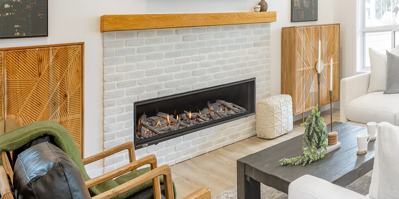 A modern hearth with light colored bricks, a wooden mantel, and a linear gas fireplace