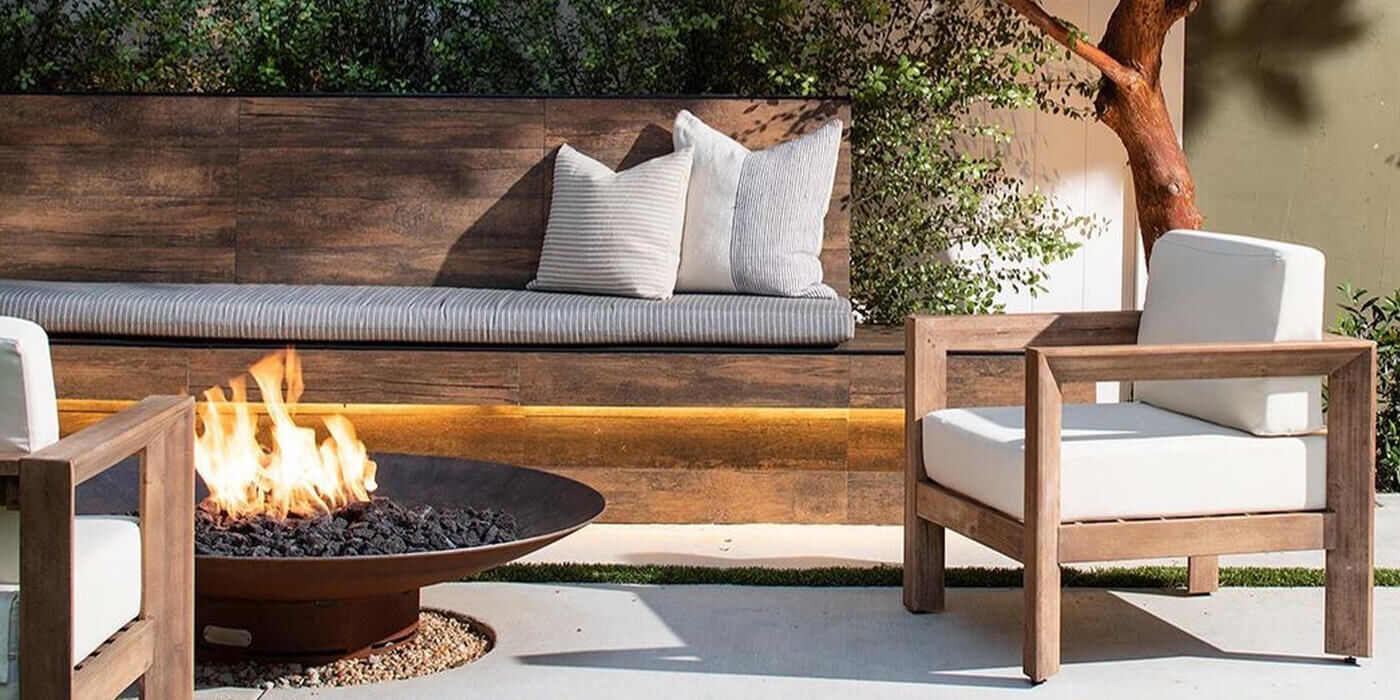 An outdoor patio space with furniture and a gas fire pit