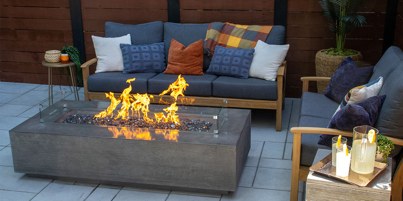 An outdoor living space with a gray Zen Gas Fire Pit by FlameCraft