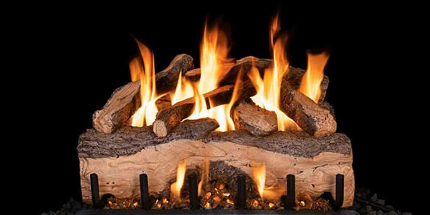 A Vented gas log set burning on a traditional black fireplace grate.