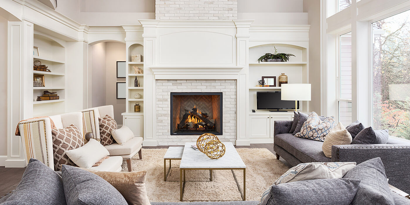 A contemporary living room with a large hearth and traditional looking gas fireplace